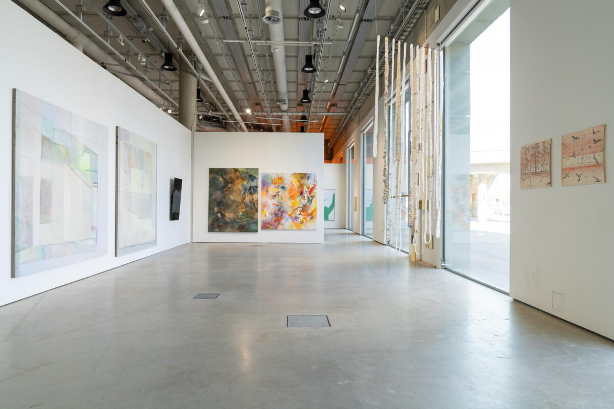 Artworks in a gallery space with big windows.