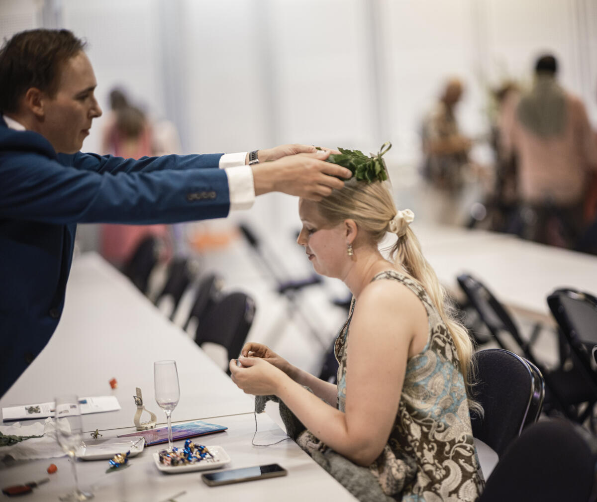 Mies asettaa seppeleen naisen päähän